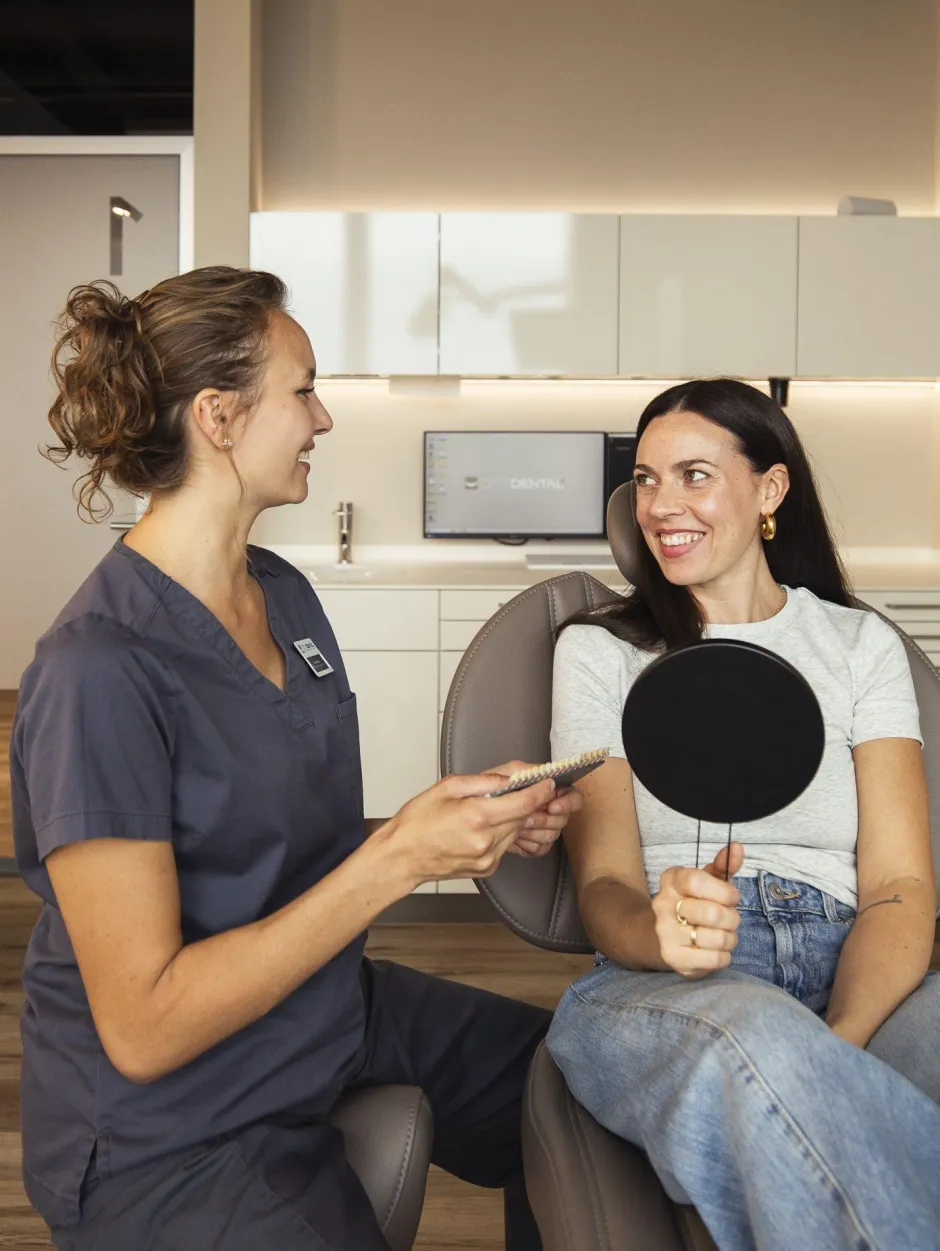 Dentalhygienikerin der Zahnarzt-Praxis CITYDENTAL, im freundlichen Gespräch mit einer Patientin und Aufklärung zur professionellen Dentalhygiene, in entspannter Atmosphäre im Behandlungszimmer.