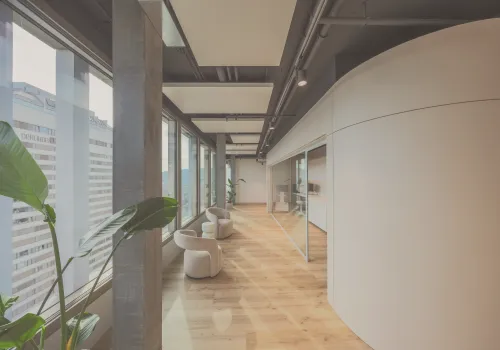 Atemberaubender Wartebereich der Zahnarzt-Praxis CITYDENTAL Oerlikon im Franklinturm. Der moderne Raum ist mit bequemen Sesseln, Tischen, Pflanzen und einem schönen Ausblick über Oerlikon ausgestattet.