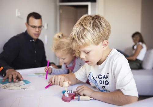 Toll eingerichtetes Kinderspielzimmer in der Zahnarzt-Praxis CITYDENTAL Oerlikon im Franklinturm. Der Raum bietet einen Maltisch, Spielsachen, Bücher und eine Couch zum Spielen und Entspannen für Kinder und Eltern.