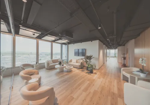 Geräumiges Wartezimmer der Zahnarzt-Praxis CITYDENTAL Oerlikon im Franklinturm, mit gemütlichen Sesseln, Tischen und Couches, die zum Entspannen und Wohlfühlen einladen.