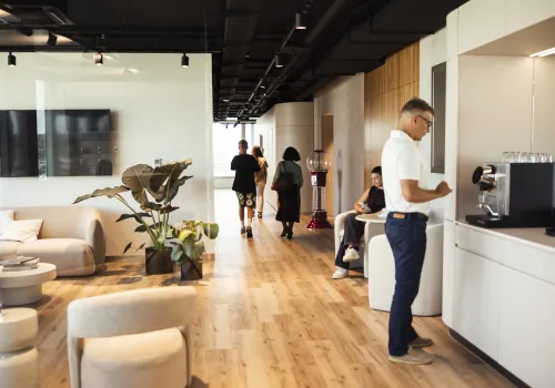 Geräumiges Wartezimmer der Zahnarzt-Praxis CITYDENTAL Oerlikon im Franklinturm, mit gemütlichen Sesseln, Tischen und Couches, die zum Entspannen und Wohlfühlen einladen.