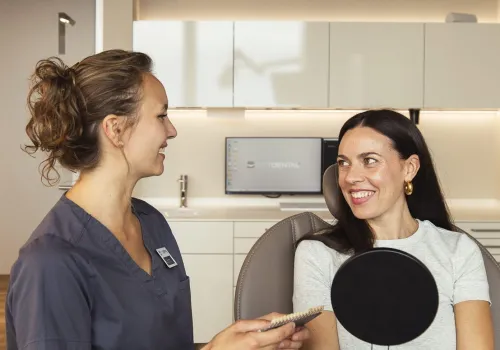 Dentalhygienikerin der Zahnarzt-Praxis CITYDENTAL Oerlikon in Zürich, im freundlichen Gespräch mit einer Patientin und Aufklärung zur professionellen Dentalhygiene, in entspannter Atmosphäre im Behandlungszimmer.