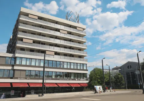 Aussenaufnahme der Liegenschaft in der das zahnärztliche Kompetenzzentrum CITYDENTAL Stettbach ist, der Himmel ist blau mit weissen Schäfchenwolken