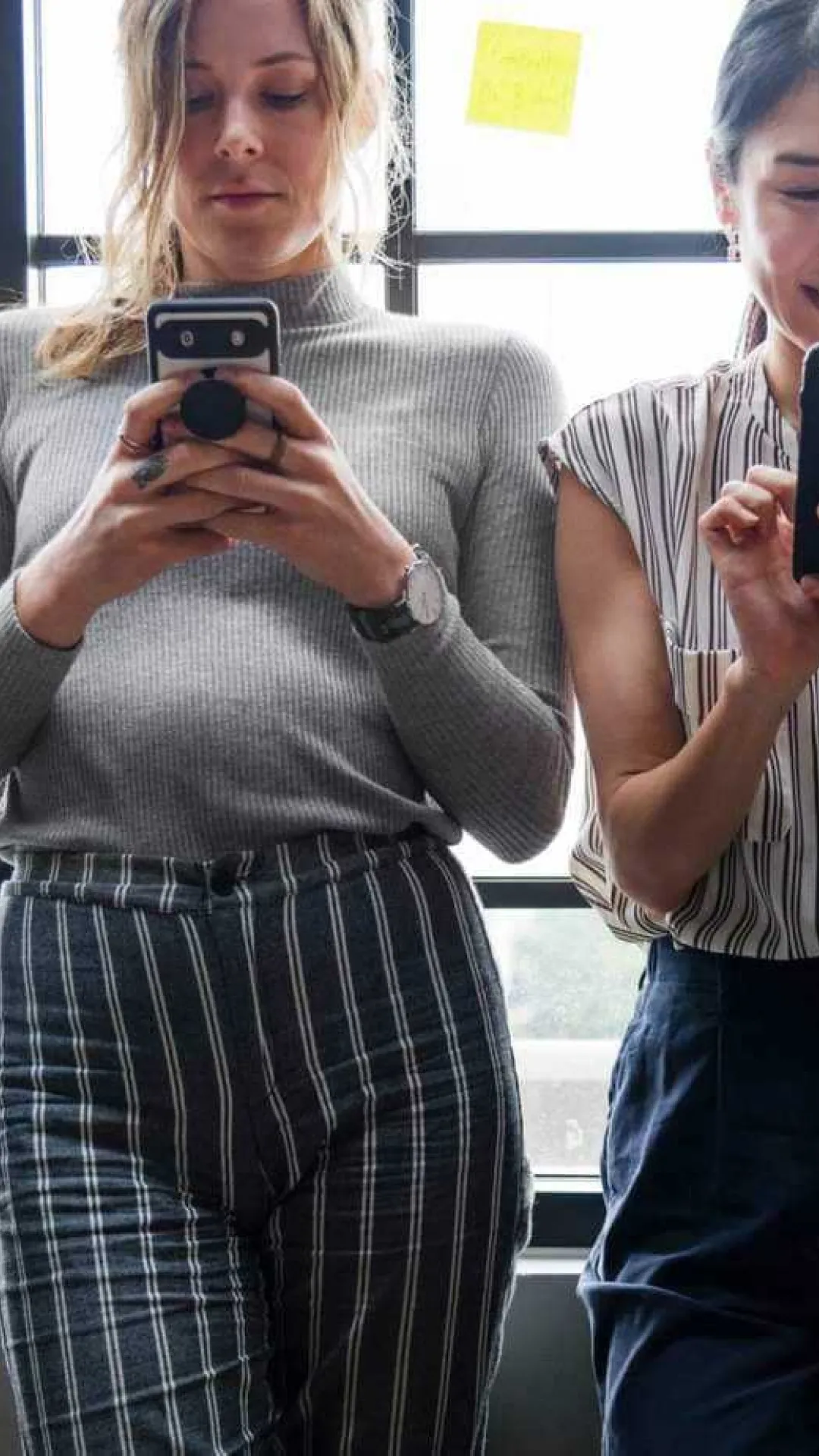Bildausschnitt vom Oberkörper von 4 Leuten, die am Handy etwas eintippen